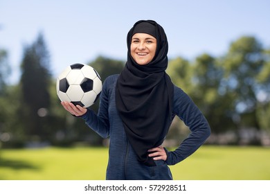 Sport, Fitness, Soccer And People Concept - Happy Muslim Woman In Hijab With Football Over Summer Natural Background