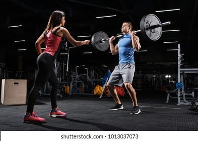 Sport, Fitness, Teamwork And Couple Concept. Female Personal Trainer Motivating Athlete Training With Barbell In A Gym.