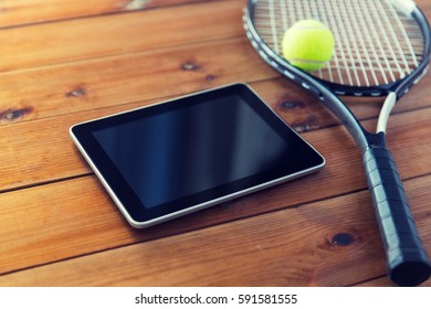 Sport, Fitness, Technology, Game And Objects Concept - Close Up Of Tennis Racket With Ball And Tablet Pc Computer On Wooden Floor