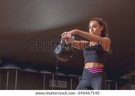 sport, fitness, weightlifting and training concept - group of people with kettlebells and heart-rate trackers exercising in gy