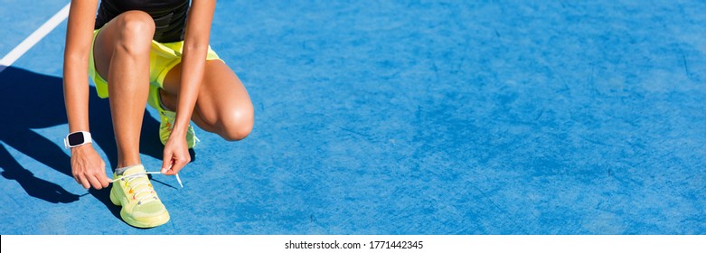 Sport fitness woman getting ready to run on in track and field stadium outside. Woman athlete tying running shoes for competition on blue floor. Banner panorama. - Powered by Shutterstock