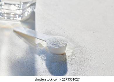 Sport food supplement powder with natural beige background and props. Supplement, creatine, hmb, bcaa, amino acid or vitamine in a white scoop. Sport nutrition concept... Check my profile for more! - Shutterstock ID 2173381027