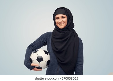 Sport, Football And People Concept - Happy Muslim Woman In Hijab With Soccer Ball Over Blue Background