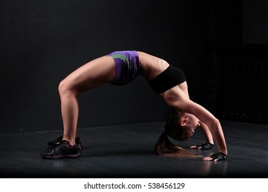 Sport Girl Doing Exercise On A Black Background.