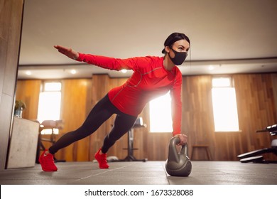 Sport Girl In Mask from Coronavirus doing Kettlebells Planking. - Powered by Shutterstock