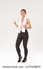 Sport, gym and healthy body concept. Full length of satisfied smiling female athlete, cute asian girl show thumbs-up after good fitness training, workout exercises in gym, white background - Shutterstock ID 2179198879