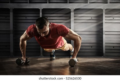 Sport. Handsome man doing push ups exercise with one hand in fitness gym - Powered by Shutterstock