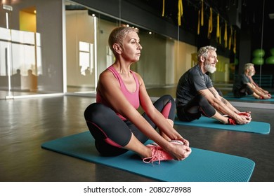 Sport and health concept. Senior couple sitting on the mat next to each other. Stress relief activities for active sportspeople after workout. - Powered by Shutterstock
