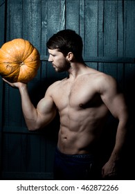 Sport And Health Food, Halloween Gourd. Young Man With Muscular Body And Pumpkin