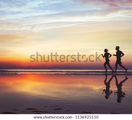 sport and health, two runners on the beach, silhouette of people jogging at sunset, man and woman healthy lifestyle background