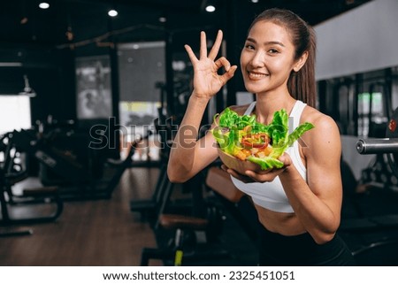sport healthy beautiful asian woman showing vegetables mix salad for diet food low calories in fitness sport club Foto stock © 