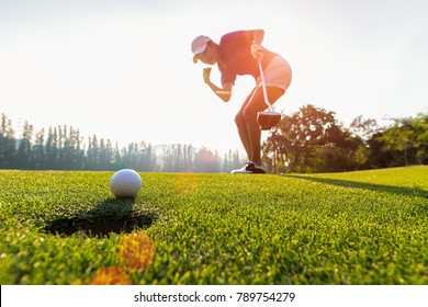 Sport Healthy. Golfing Game. Asian Ladies Woman Golfer Action To Win After Winner Long Putting Golf Ball On The Green Golf, Outdoors Sunset Time, Copy Space.  Healthy Concept