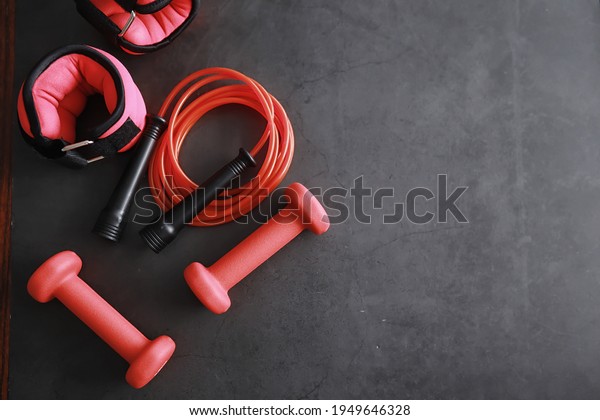 Sport and healthy lifestyle. Accessories for\
sports. Yoga mat dumbbell and jump rope. Sports background with\
home exercises concept.