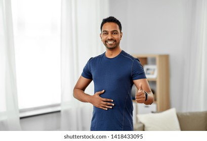 Sport And Healthy Lifestyle Concept - Smiling Indian Man With Fitness Tracker Showing Thumbs Up At Home