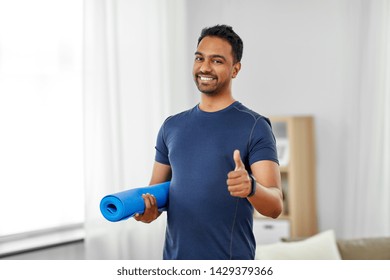 sport and healthy lifestyle concept - smiling indian man with fitness tracker showing thumbs up at home - Shutterstock ID 1429379366