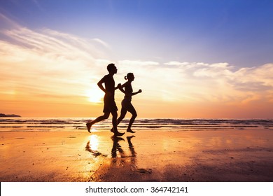 sport and healthy lifestyle, two people jogging at sunset on the beach - Powered by Shutterstock