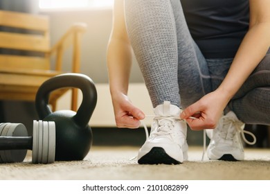 Sport and healthy woman tying her shoes, Workout at home. Getting ready for training - Shutterstock ID 2101082899