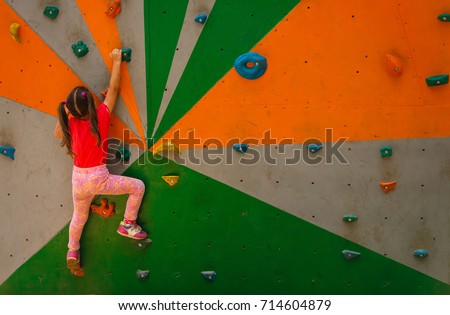Sport image of climbing little girls to the top of wall