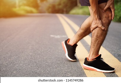 Sport Injury. Accident Concept,Young Fitness Man Holding His Sports Leg Injury, After Running And Exercise Outside In Summer.