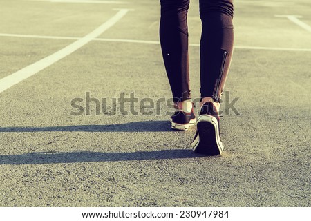 sport legs girl sneakers on the pavement