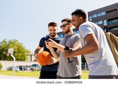 Sport, Leisure Games And Male Friendship Concept - Group Of Men Or Friends With Smartphone At Outdoor Basketball Playground