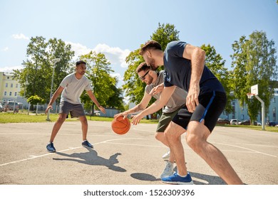 Sport, Leisure Games And Male Friendship Concept - Group Of Men Or Friends Playing Street Basketball