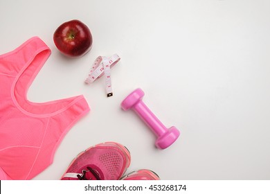 Sport Lifestyle Concept. Top View Of Dumbbell, Apple, Measuring Tape, Sneakers And Sport Accessories On White Desk.