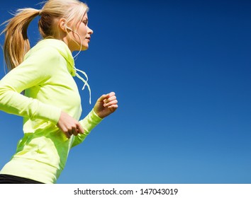 sport and lifestyle concept - woman doing running with earphones outdoors - Powered by Shutterstock