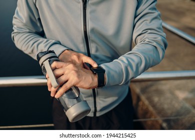sport man checking at smartwatch during training and running in the park.  - Shutterstock ID 1944215425