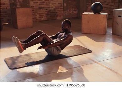 Sport Man Doing Abs Exercise Workout At Gym Indoors. Black Male Athlete Exercising On Yoga Mat, Doing Abdomen Muscle Training At Fitness Club