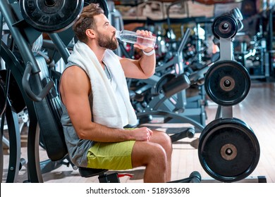 Sport Man Drinking Water In The Gym