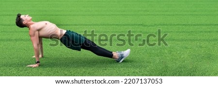 sport man on green grass, copy space. sport reverse plank exercise outdoor. reverse plank