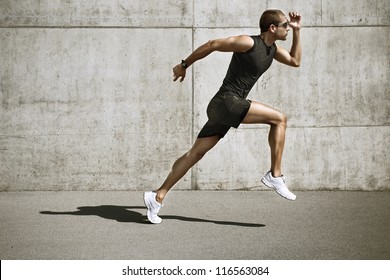 спортивный человек начинает бегать. Молодой человек бег трусцой передняя цементная стена