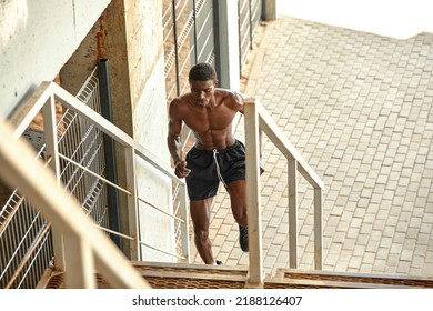 Sport Motivation. Black Male Athlete Running Up On Urban Stairs Outdoors, Enjoying Morning Workout, With Free Space