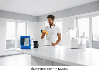 Sport Nutrition. Healthy Handsome Man With Fit Body Preparing Energy BCAA Shake In Bottle In Kitchen. Sexy Muscular Male Making Drink Before Fitness Workout. Sports Bodybuilding Amino Acid Supplements