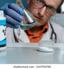 Sport Nutrition Supplement In Lab. Doctor Examines Liquid BCAA Concentrate. Close Up.