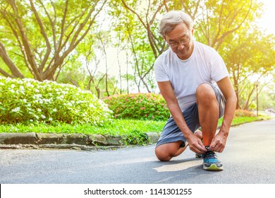 Sport Old Man Or Senior Runner Tying Shoelaces Getting Ready Jogging In Park . Elder Male Start Running . Mature Being To Exercise .  Retirement  Workout . Retired Fitness Older Chinese Fit . Japanese