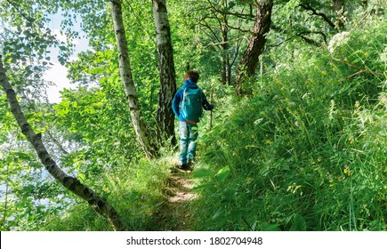 Sport Orienteering In Forest For Kids.  
Boy Traveler Walks On A Touristic Hiking Trail To A Family Tent Camp On The Shore Of A Forest Lake In The Mountains.