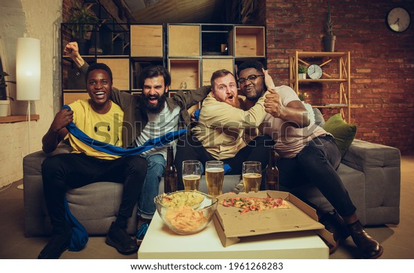 Sport party. Group of friends watching TV,\
sport match together. Emotional fans cheering for favourite team,\
watching football. Concept of friendship, leisure activity,\
emotions. Betting, finance,\
fun