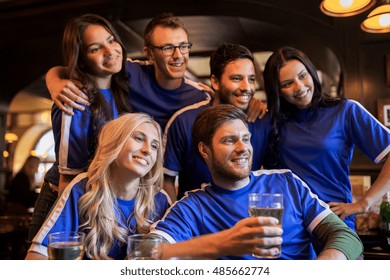 sport, people, leisure, friendship and entertainment concept - happy football fans or friends drinking beer at bar or pub - Powered by Shutterstock