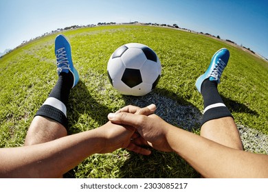 Sport, pov and shoes of man with soccer ball outdoor, relax and resting after fitness or training. Football, field and hands of male player relaxing on grass at park after workout, match or sports - Powered by Shutterstock