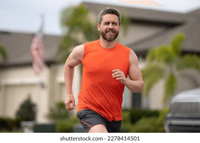Corredora deportiva. Hombre corriendo. Un modelo de fitness para hombres en forma de sprint al aire libre. Hombre atractivo corriendo rápido, entrenando al aire libre, corredor trotando por la calle estadounidense.