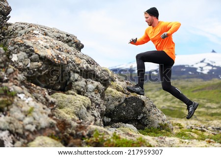 Sport running man in cross country trail run. Fit male runner exercise training and jumping outdoors in beautiful mountain nature landscape with Snaefellsjokull, Snaefellsnes, Iceland.