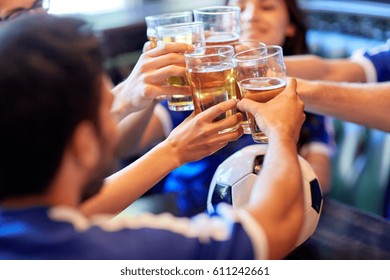 Sport, Soccer, People And Leisure Concept - Happy Friends Or Football Fans Clinking Beer Glasses At Bar Or Pub