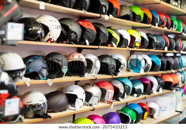 Sport store interior with rows of multi-colored\
skiing helmets