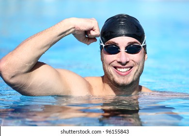 Sport swimmer winning. Man swimming cheering celebrating victory success smiling happy in pool wearing swim goggles and black swimming cap. Caucasian male fit fitness model. - Powered by Shutterstock