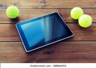 Sport, Technology, Game And Objects Concept - Close Up Of Three Yellow Tennis Balls And Tablet Pc Computer On Wooden Floor