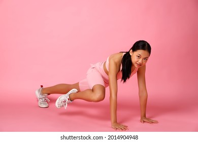 Sport Teenager Girl Planking And Lift Her Leg, Do Fashion Power Poses. 12 Years Old Asian Youth Athlete Kid Wear Pastel Pink Fitness Cloth Pants Over Pink Background Full Length