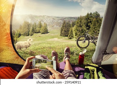 Sport. Tourism. Traveling. Cyclist In The Tent With The Mobile