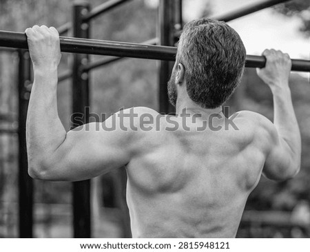 Sport training. Man do pullup exercise. Muscular biceps and triceps. Strong athlete. Man pullup at outdoor gym. Muscular man with strong back muscle. Gym bar. Sport pullup workout. Bodyweight.